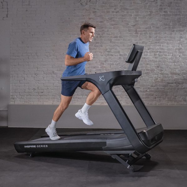 Man running on Inspire Centr T7s treadmill while it is inclined up