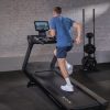 Left corner view of person running on Inspire T7s treadmill while it is inclined